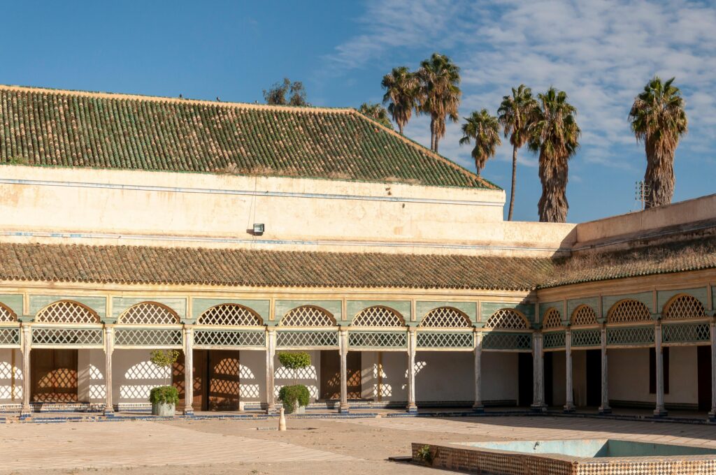 Grand Courtyard of aged historical Bahia Palace with arched passage located against blue sky in Marrakesh