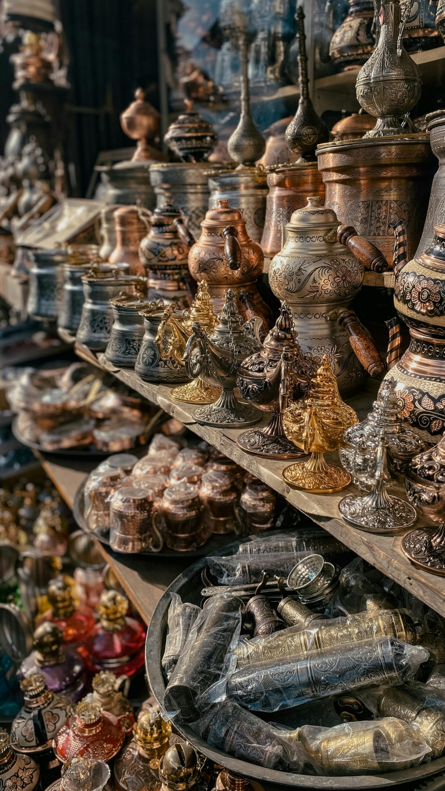 A variety of traditional metal jugs and crafts displayed on store shelves, showcasing intricate craftsmanship.