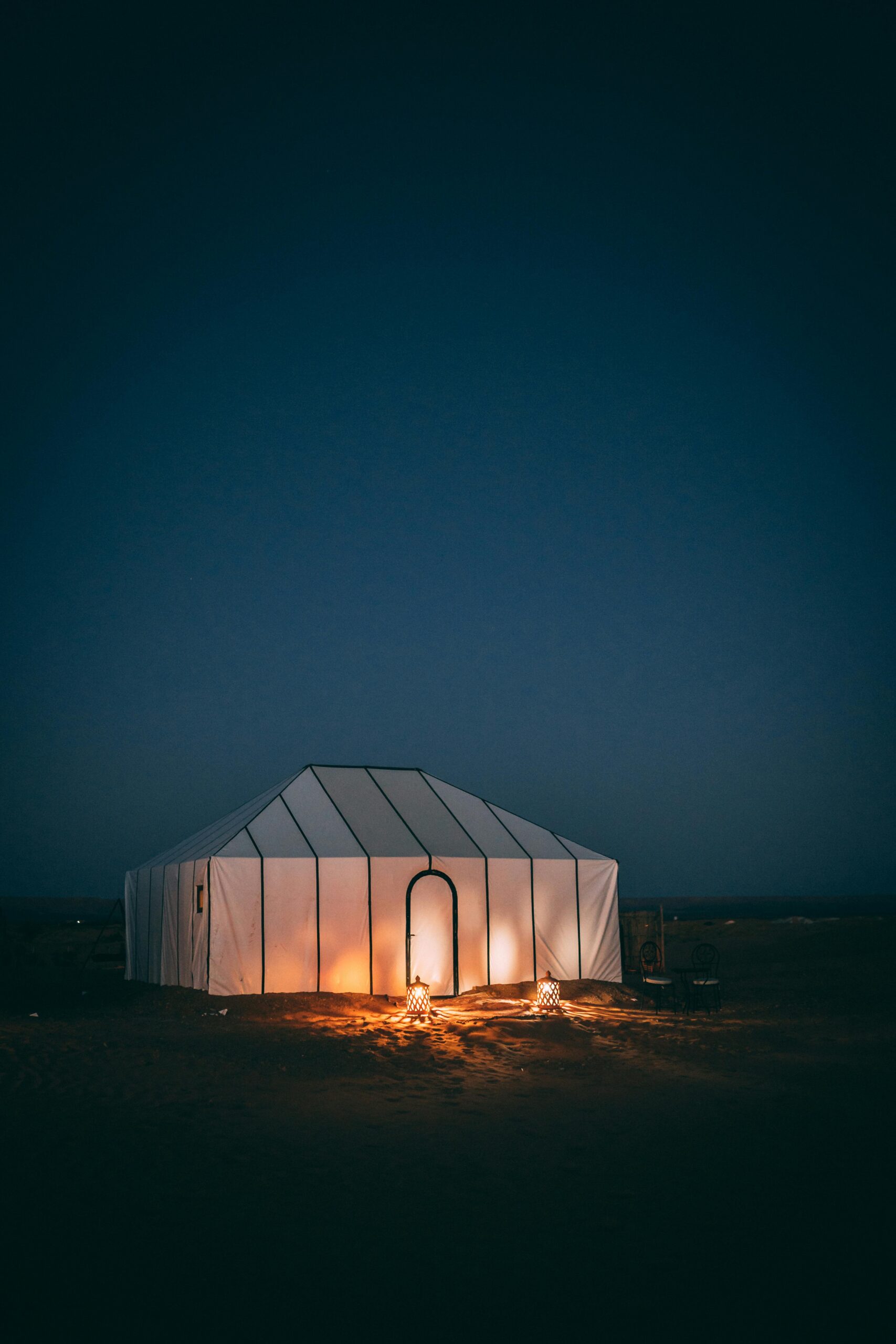 Morocco's Premier Desert Stargazing Locations Morocco Service Tours A serene night scene of a glowing tent in the Sahara Desert under a starry sky.