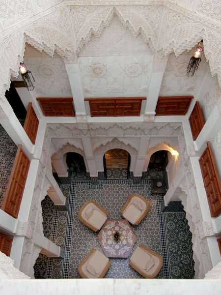 Stunning high-angle view of a traditional Moroccan riad courtyard in Marrakech, showcasing intricate architecture.
