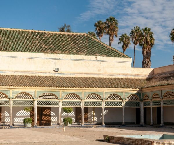 Grand Courtyard of aged historical Bahia Palace with arched passage located against blue sky in Marrakesh